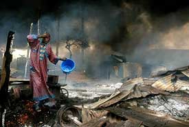 A man rinses soot from his face at the scene of a petrol pipeline explosion. 